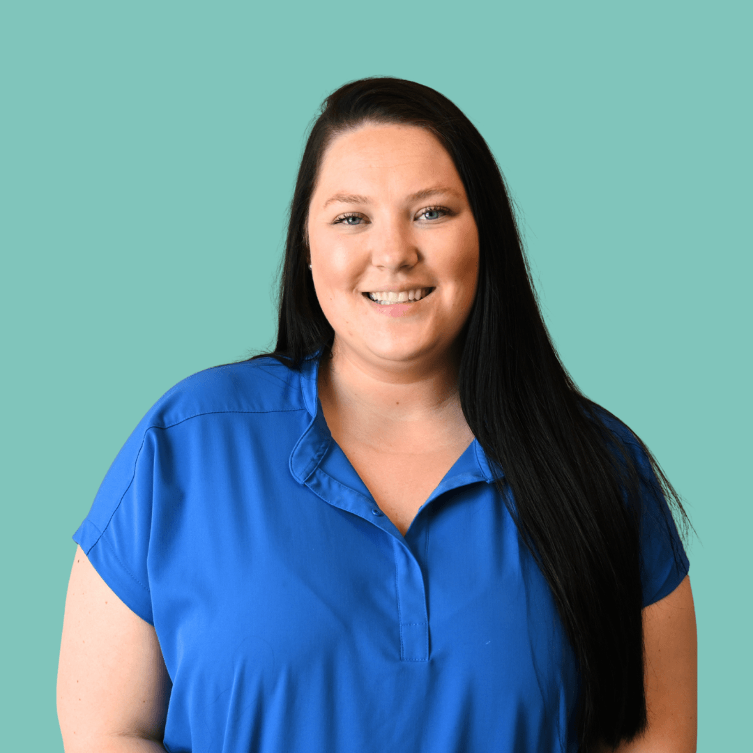 Kaitlyn Brooks, wearing a blue shirt and black scrubs